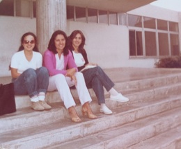 Tres amigas, sentadas en unos escalones a finales de los 70 o principios de los 80. Su pose y vestimenta reflejan una amistad cercana y un estilo de vida casual y moderno.