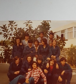 La fotografía muestra un grupo de jóvenes estudiantes, vestidos con monos de trabajo, en La Laboral, a finales de los años 70, transmitiendo un ambiente joven y cordial.