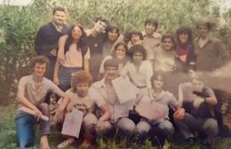 La fotografía muestra a un grupo de alumnos y alumnas, participando en una actividad creativa al aire libre en un entorno natural, con una estética de principios de los 80 y un ambiente amistoso y relajado.