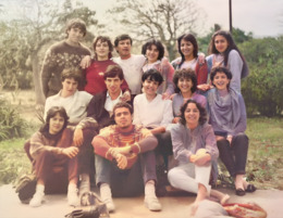 Un grupo de alumnos y alumnas en uno de los jardines de La Laboral, capturados en un momento relajado y amistoso, con una estética de los años 80.